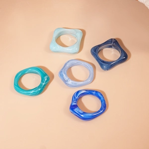 Détail de 5 bagues en acrylique bleu marbré aux formes carrées et rondes irrégulières