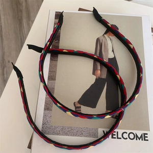 Detail of colorful woven plaid headbands with elastic bands on a minimalist book background