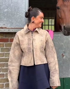 Dettaglio della giacca in pelle scamosciata marrone vintage con zip e texture usurata