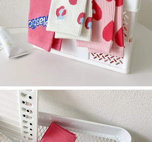 Detail of pink knitted mid-calf socks with heart patterns and plastic letter embroidery