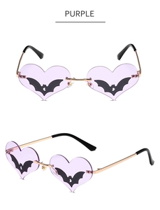 Detail view of purple heart sunglasses with bat silhouette and gold metal frame