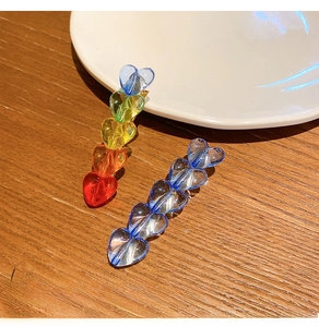 Close-up of colorful heart-shaped transparent resin hair clips on a wooden surface