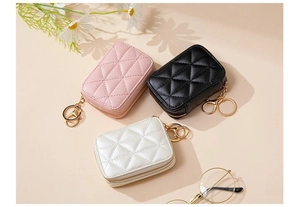 Close-up of quilted PU leather mini cosmetic bags in pink, black, and beige with gold hardware