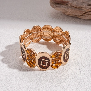 Macro detail of retro golden stretch bracelet with amber resin tiles and star motifs