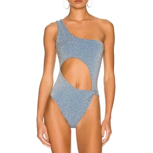 Detail of glittery blue one-shoulder swimsuit with waist cutout and sparkling fabric finish