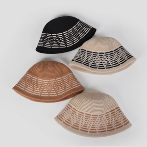 Flat lay showing four knitted bucket hats in black and beige with jacquard patterns