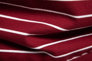 Close-up of soft wine red and white striped knit fabric showing fine texture and density