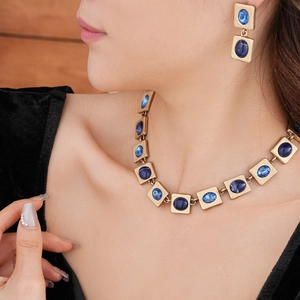 Detailansicht des Vintage-Schmucksets mit goldener Halskette, Ohrringen und blauen Steinen