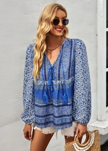 Detailed view of bohemian floral print blouse with V-neckline and tassel drawstrings