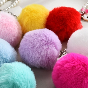 Vue macro de pompons en peluche colorés avec chaînes de perles pour sacs et clés