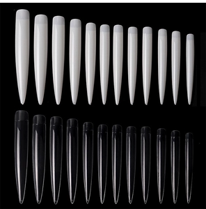 Dettaglio macro di unghie finte stiletto bianche e trasparenti con numeri di misura