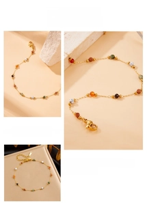Macro detail of gold stainless steel chain bracelet with colorful gemstone beads and clasp