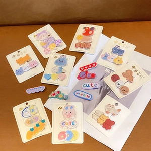 Macro detail of various cute cream-colored animal and cartoon hair clips for girls
