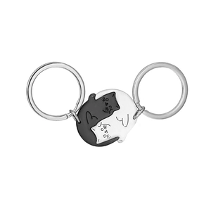 Vue macro de porte-clés chat noir et blanc en acier inoxydable avec motif Tai Chi