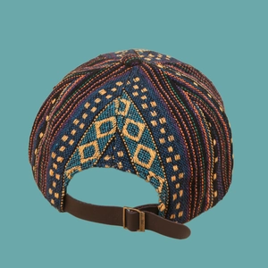 Detail of ethnic woven baseball cap featuring leather back strap and metal buckle