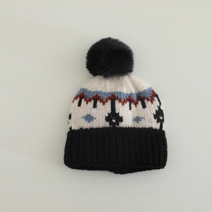 Dettaglio del cappello in maglia Fair Isle con pompon nero e motivo jacquard geometrico
