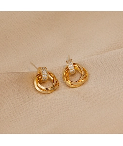 Close-up of elegant gold interlocking triple rings earrings with crystal pave detail