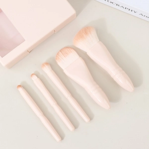 Detailed view of five soft pink makeup brushes with gradient bristles and matte handles