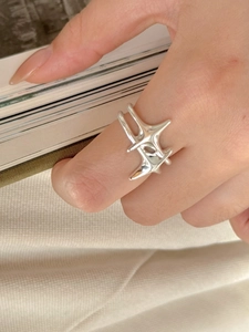 Macro shot of S925 sterling silver ring with abstract star design on a model's finger