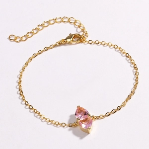 Detail of gold chain bracelet with two pink heart-shaped crystals and adjustable clasp