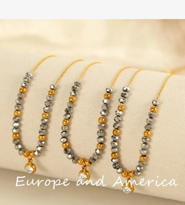 Detailed shot of beaded titanium steel necklace with gold beads and zircon pendant