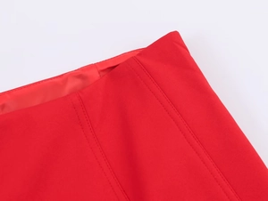 Detail of red polyester skirt showing clean stitching and high-quality fabric texture