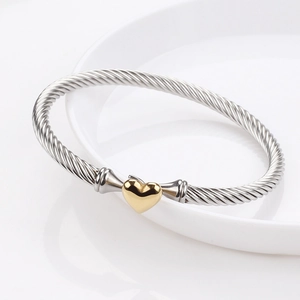 Silver stainless steel cable wire bracelet featuring a polished gold heart center charm