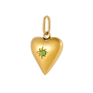 Macro shot of gold heart pendant with green gemstone in a starburst setting