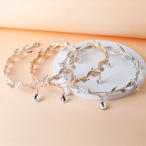 Close-up of gold and silver leaf bridal crowns with rhinestone teardrop pendants