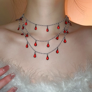 Detailed view of layered silver fringe necklace with red teardrop gems and white pearls