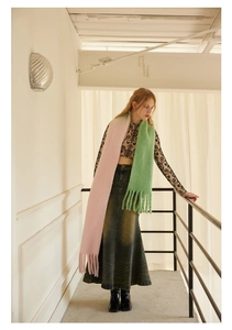 Detail of pink and green gradient wool scarf with soft fringe tassels and plush texture
