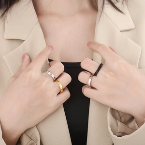 Polished stainless steel minimalist rings shown in gold, silver, black, and rose gold