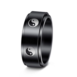 Macro detail of 8mm black brushed stainless steel spinning ring with Tai Chi pattern