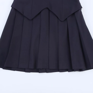 Detailed top view of a black pleated mini skirt with unique pointed overlap waist layers