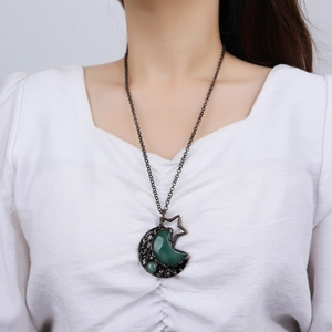 Vintage bronze moon and star necklace with green aventurine pendant on white blouse