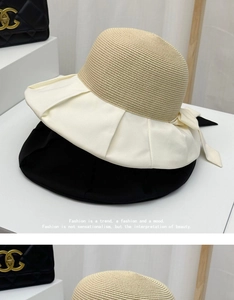 Close-up of summer straw sun hat with large brim and elegant bow tie decoration