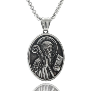Macro detail of silver Saint Benedict medal pendant on a box chain with embossed texture