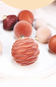 Close-up of velvet flocked Christmas balls with ripple texture and golden hooks