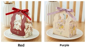Detail of luxury wedding candy gift boxes with floral prints and silk ribbons on a desk