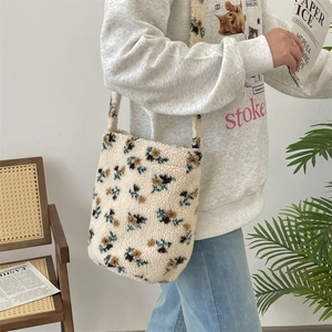 Detailed shot of a plush floral tote bag carried by a model in an autumn setting