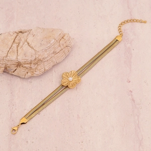 Detail of gold double snake chain bracelet with flower charm and white pearl accent