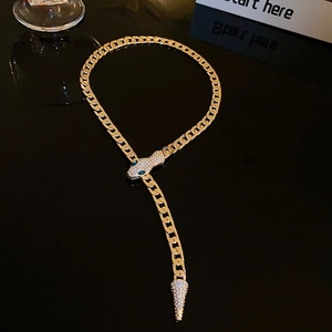 Detailed view of gold snake necklace with green eyes and crystal embellishments