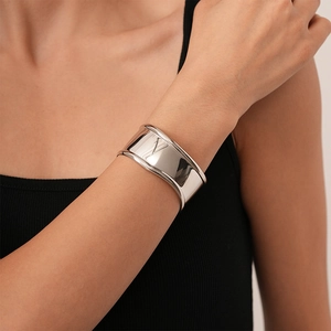 Close-up of a wide polished silver cuff bracelet with a minimalist geometric opening