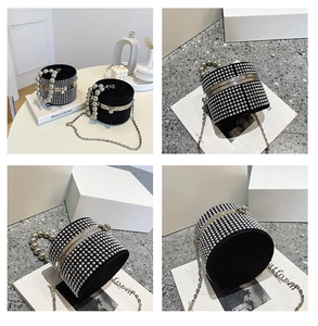 Detailed view of black cylinder bucket bag with silver rhinestones and pearl handle