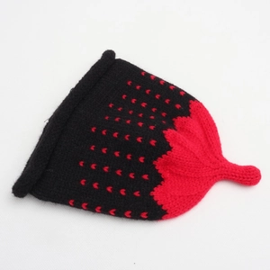 Detail of strawberry-inspired knit hat with black yarn base and red heart jacquard pattern