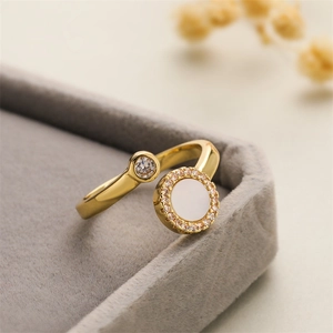 Detailed macro of a gold-plated adjustable ring featuring white shell and zircon accents