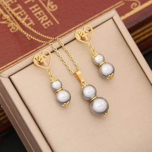 Macro shot of gray pearl gourd jewelry set with gold heart earrings on vintage books