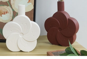Detail of matte ceramic flower vases in white and brick red with embossed line texture