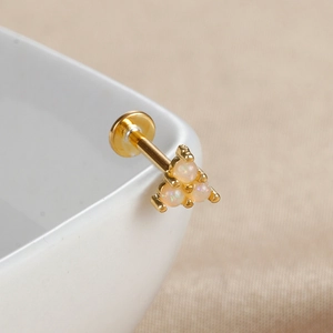Détail macro du labret en plaqué or avec trois opales disposées en grappe élégante
