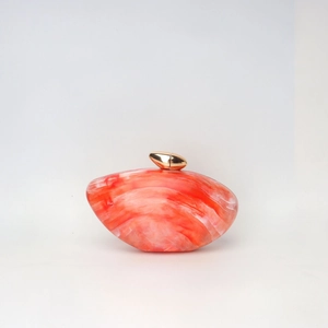 Detail of orange marble acrylic evening clutch featuring premium gold metallic clasp